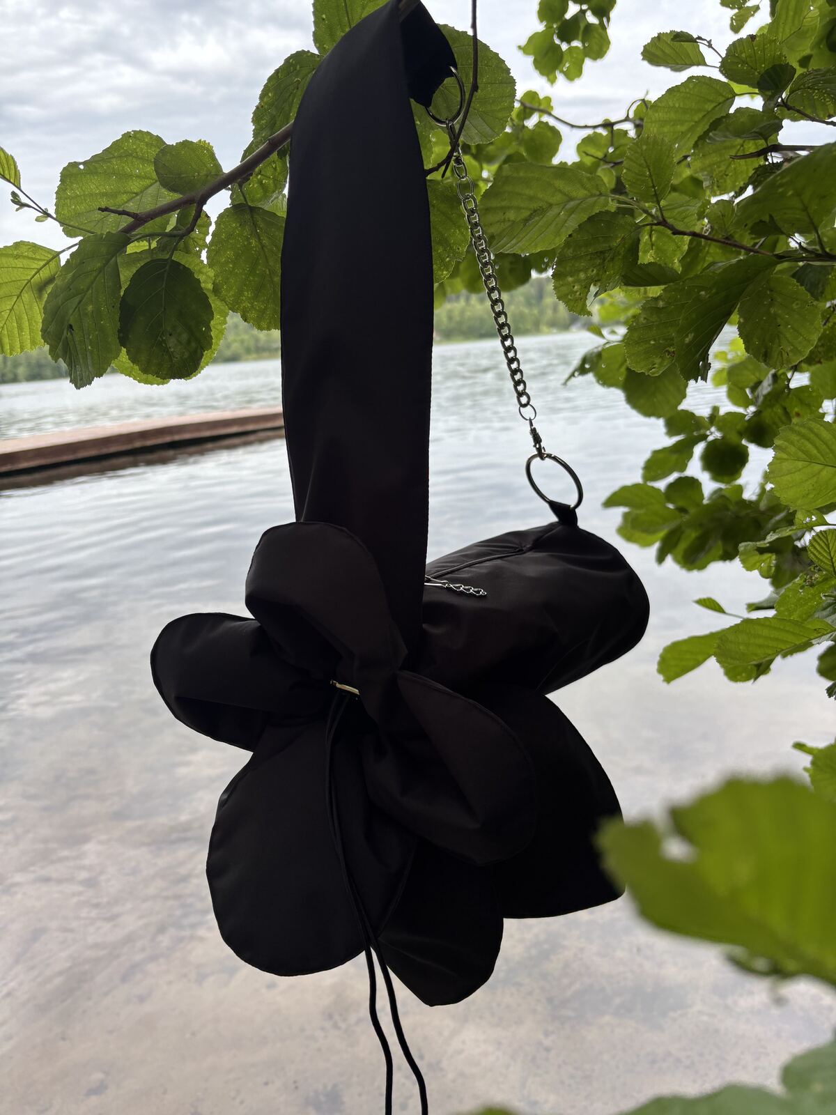 The flower bag with its chain strap, hanging by the lakeside