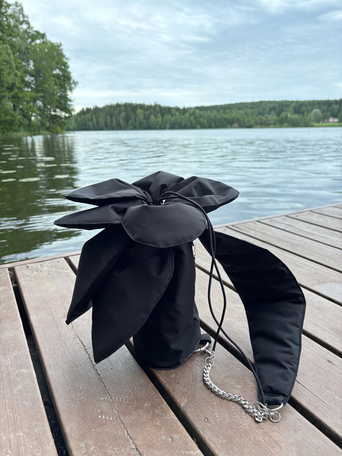The flower bag on a lakeside dock, showing the drawstring and chain strap